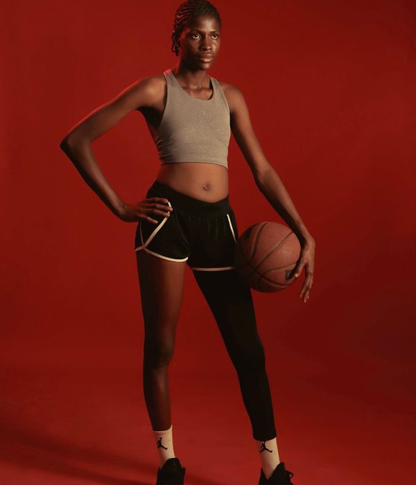 Athletic woman in a dynamic fitness pose with soft lighting.